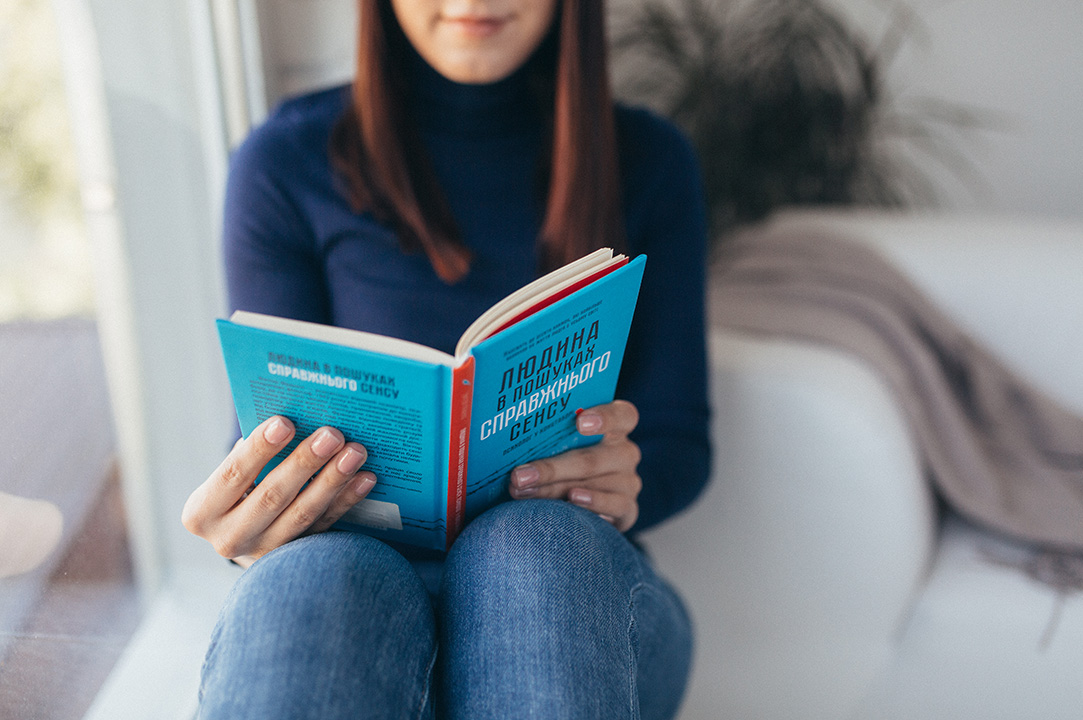 The girl is reading Viktor Frankl's book 'Man's Search for Meaning'